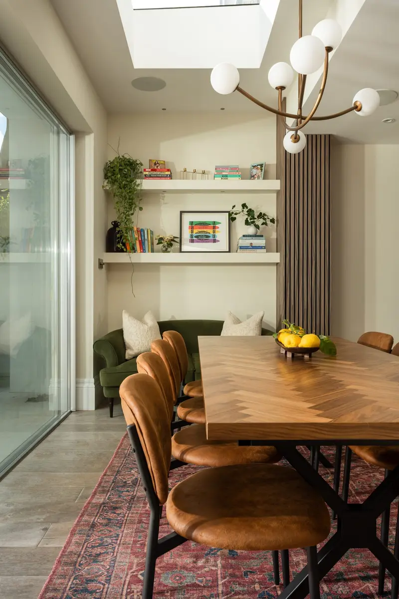 Dining room with leather chairs and a pendant chandelier under a roof light