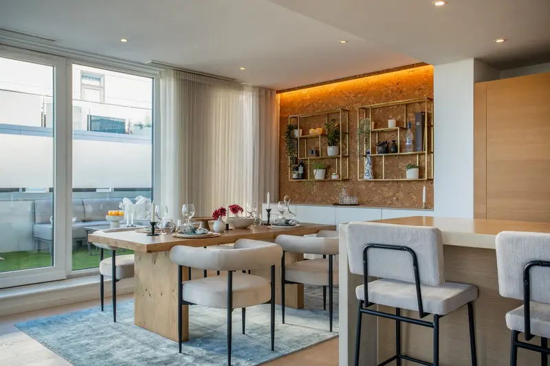 Open-plan penthouse kitchen and dining area with backlit shelving
