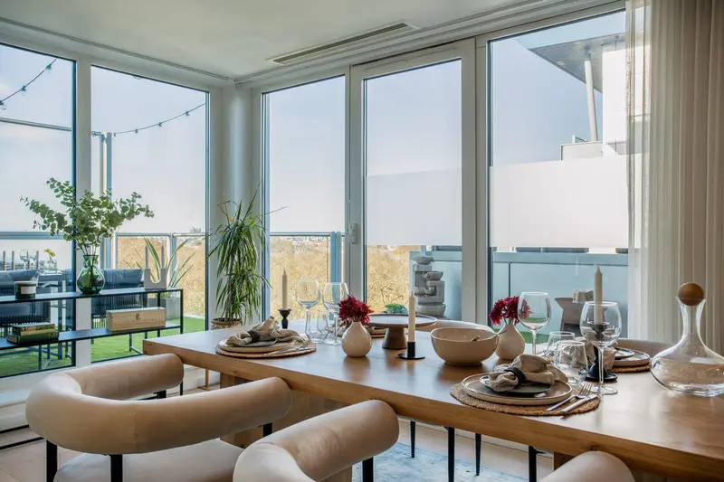 Dining table set beside floor-to-ceiling windows