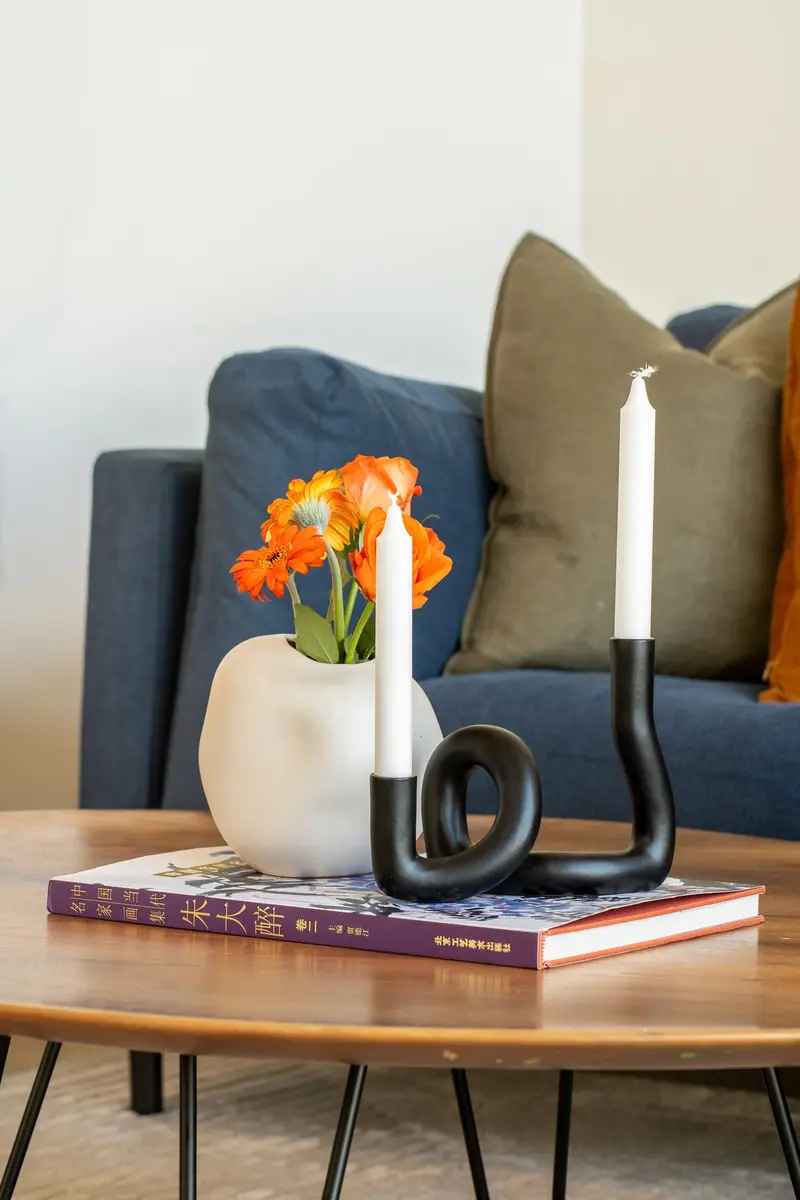 Coffee table vignette with orange tulips and a black candle holder