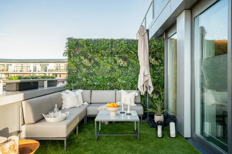 Penthouse terrace with outdoor sofa and green wall