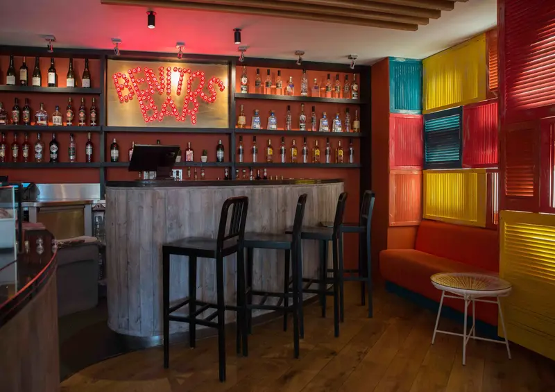 Benitos bar with a backlit shutter wall in teal, pink and orange
