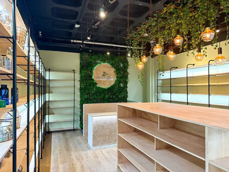 Wellness shop with oak shelving, a moss logo wall and hanging greenery