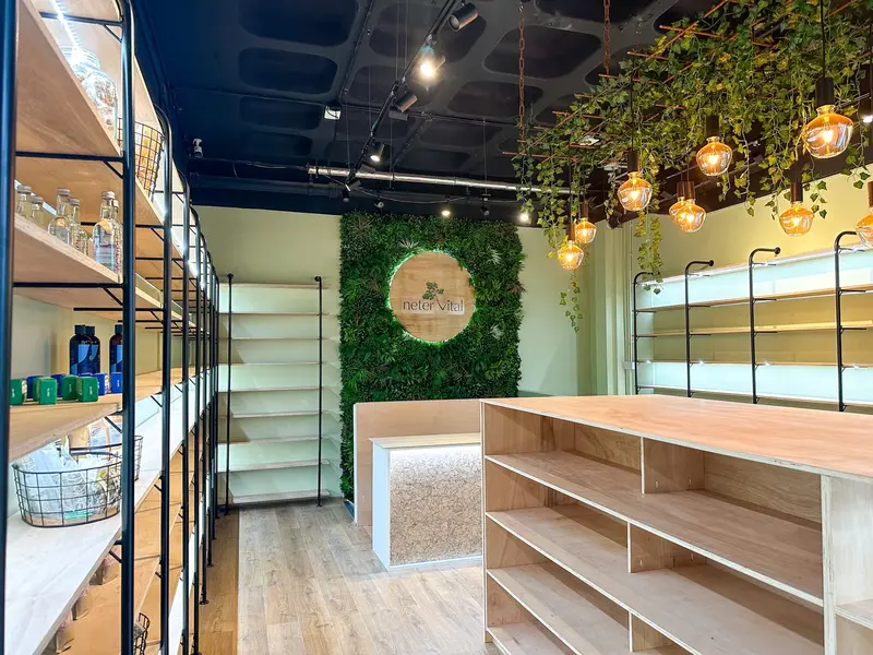 Shop interior with the living wall logo and lit shelving