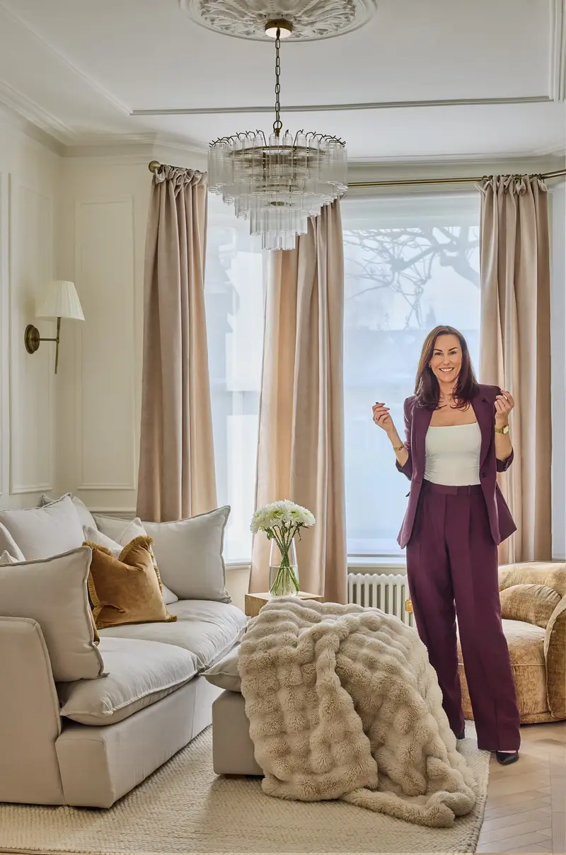 Charlotte Bergman in a cream living room with a chandelier