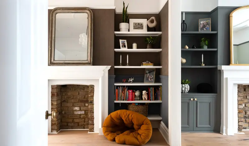 Living room with alcove shelves, exposed brick fireplace and a velvet bean bag