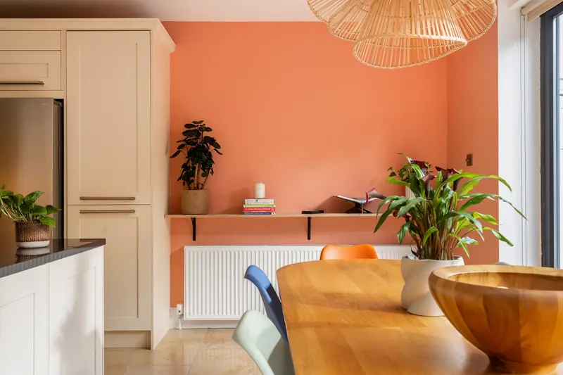 Kitchen-diner with a coral feature wall and rattan pendant