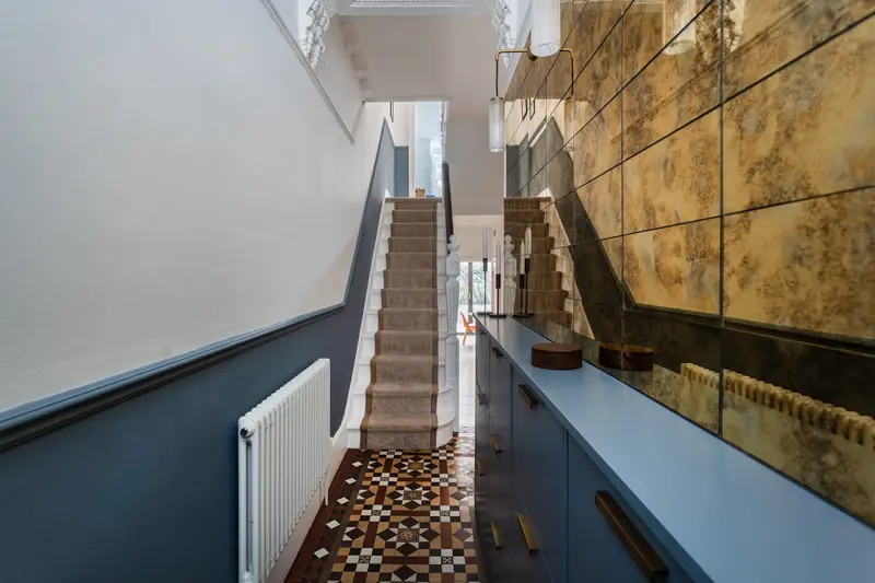 Hallway with an antique mirror wall and blue painted dado