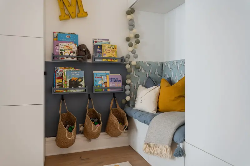 Kids’ reading nook with wall-mounted book shelves and hanging baskets
