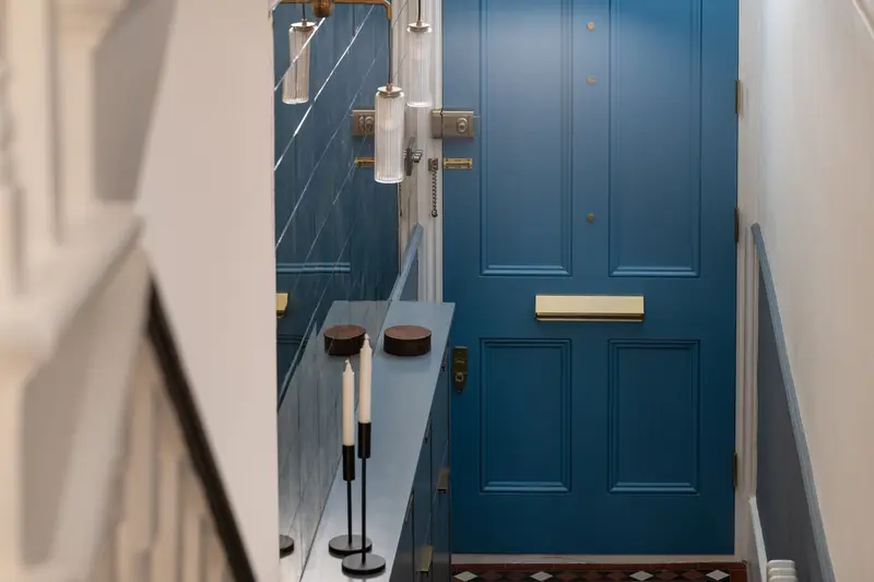 Blue Victorian front door and slim hallway console
