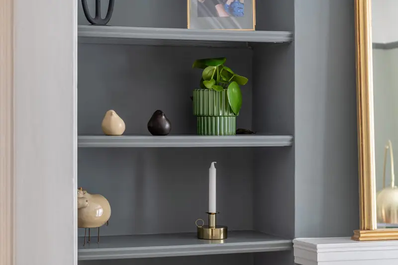 Grey alcove shelving with brass candlestick