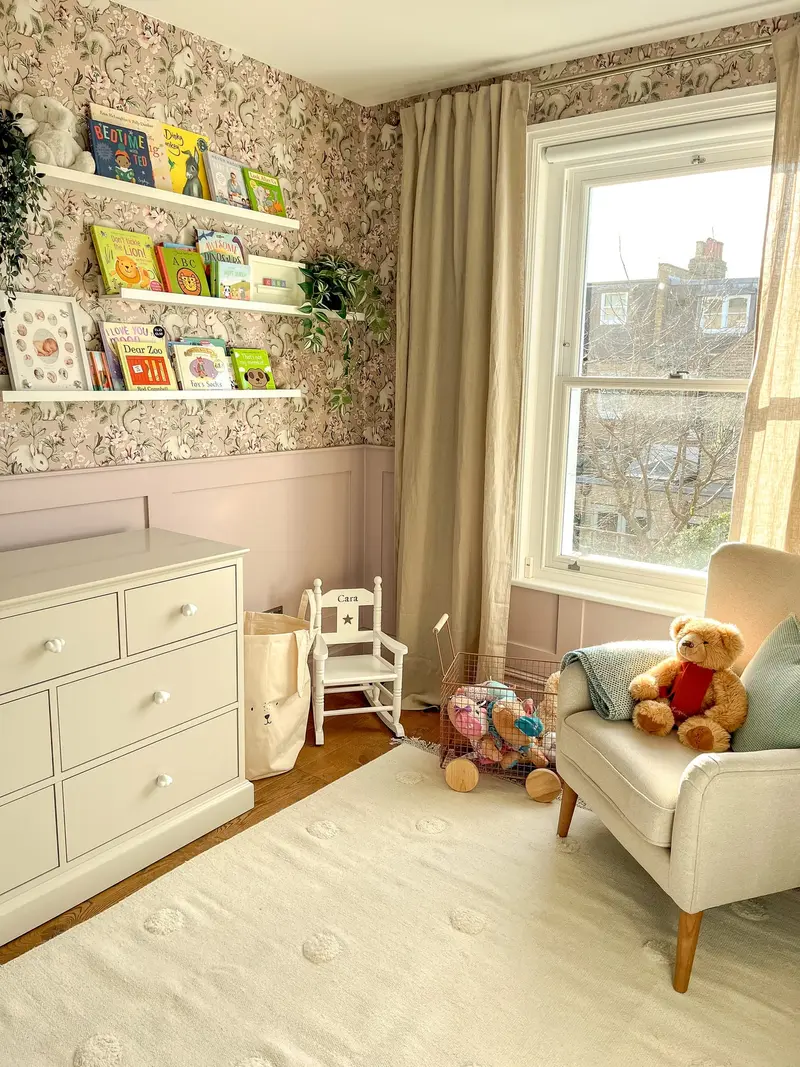 Child’s bedroom with armchair, chest of drawers and woodland wallpaper