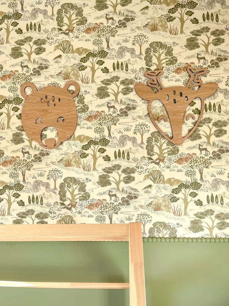 Wooden animal-head wall decorations on woodland wallpaper