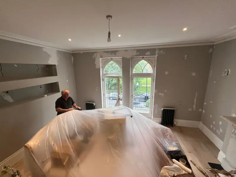 Edwardian reception room mid-renovation with floors protected in dust sheets