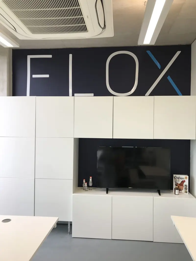 Storage wall with built-in TV and backlit Flox logo