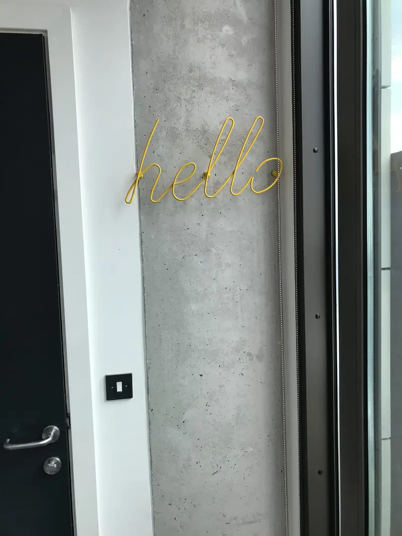 Gold hello sign on a concrete pillar