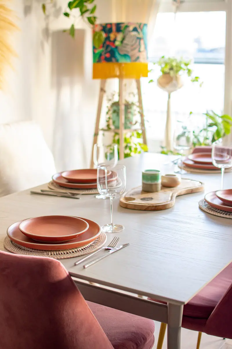 Dining table with terracotta plates and plum velvet chairs