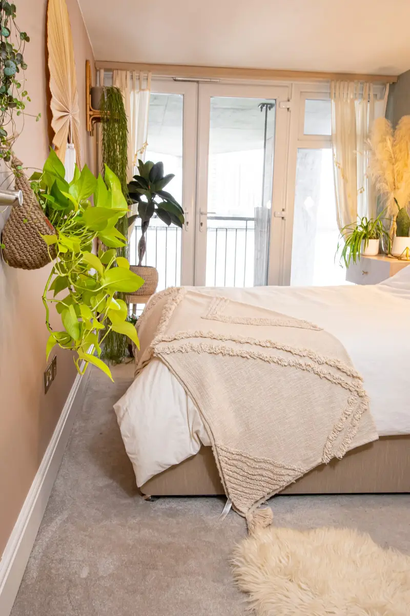 Bedroom with layered throws and trailing plants