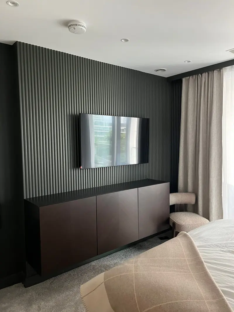 Slatted wood media wall with a mounted TV