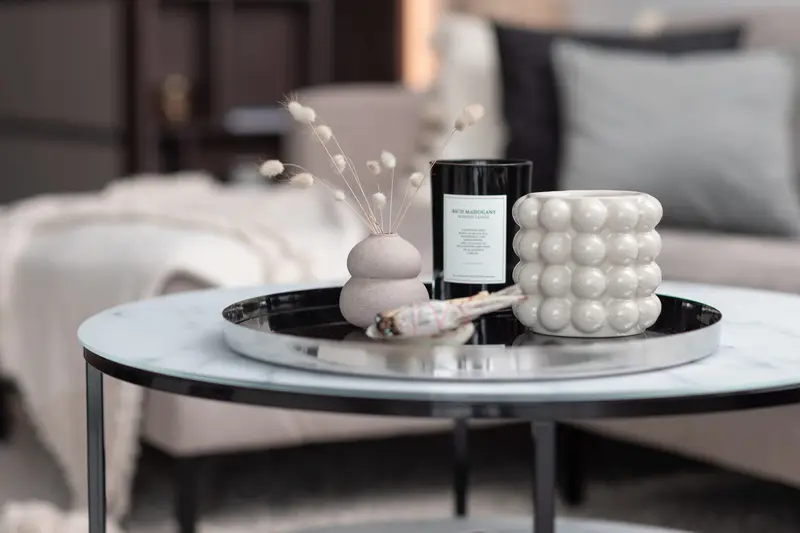 Coffee table styled with a candle and sculptural vase