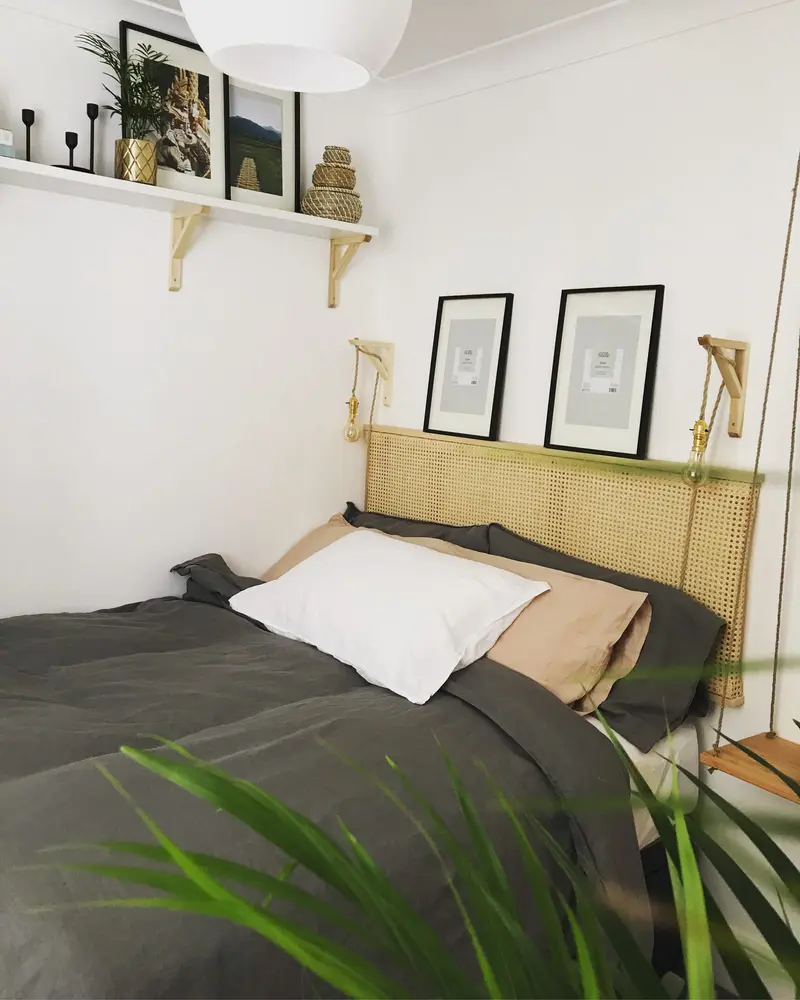 Calm spare bedroom with linen bedding, pine shelf and rattan headboard