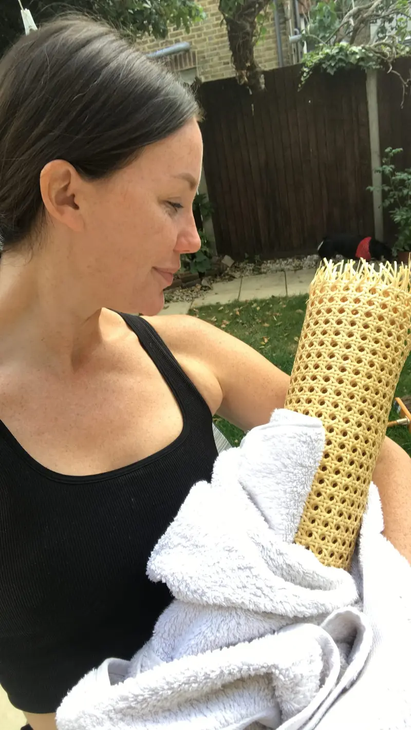 Charlotte with a roll of rattan for the DIY headboard