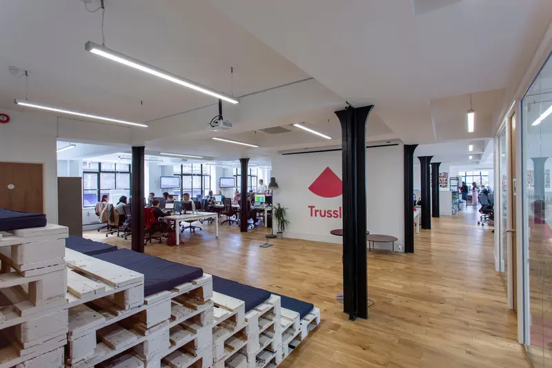 Open-plan office with pallet step seating and black steel columns