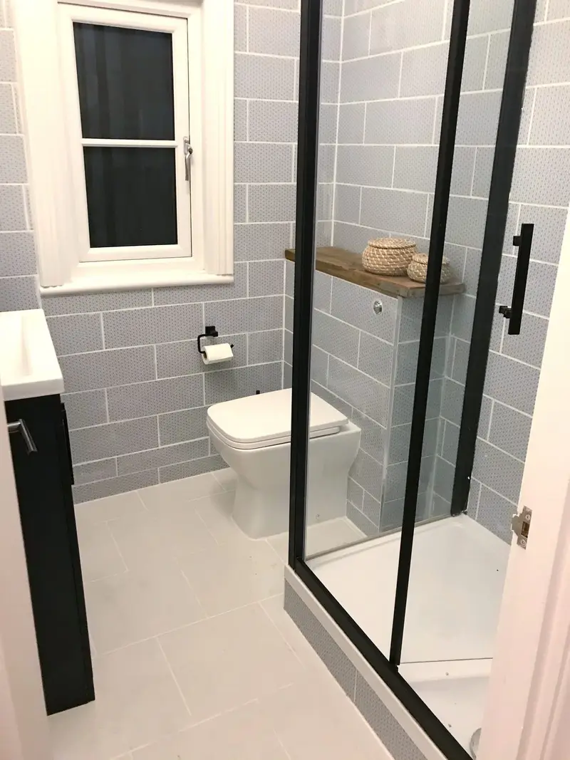 Finished bathroom with black-framed shower screen